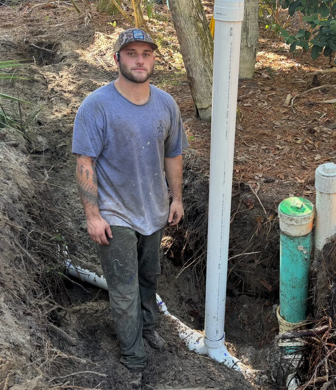 Chase Sandler beside newly installed underground plumbing